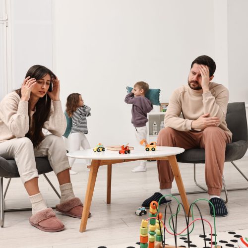 Overwhelmed parents and their naughty children at home